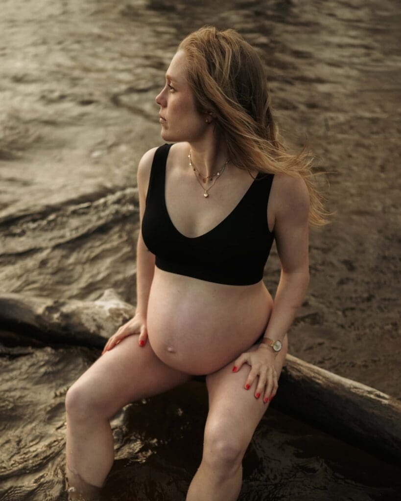 Gravid kvinna med svart bikini sitter på en gren vid Aspen i Lerum.