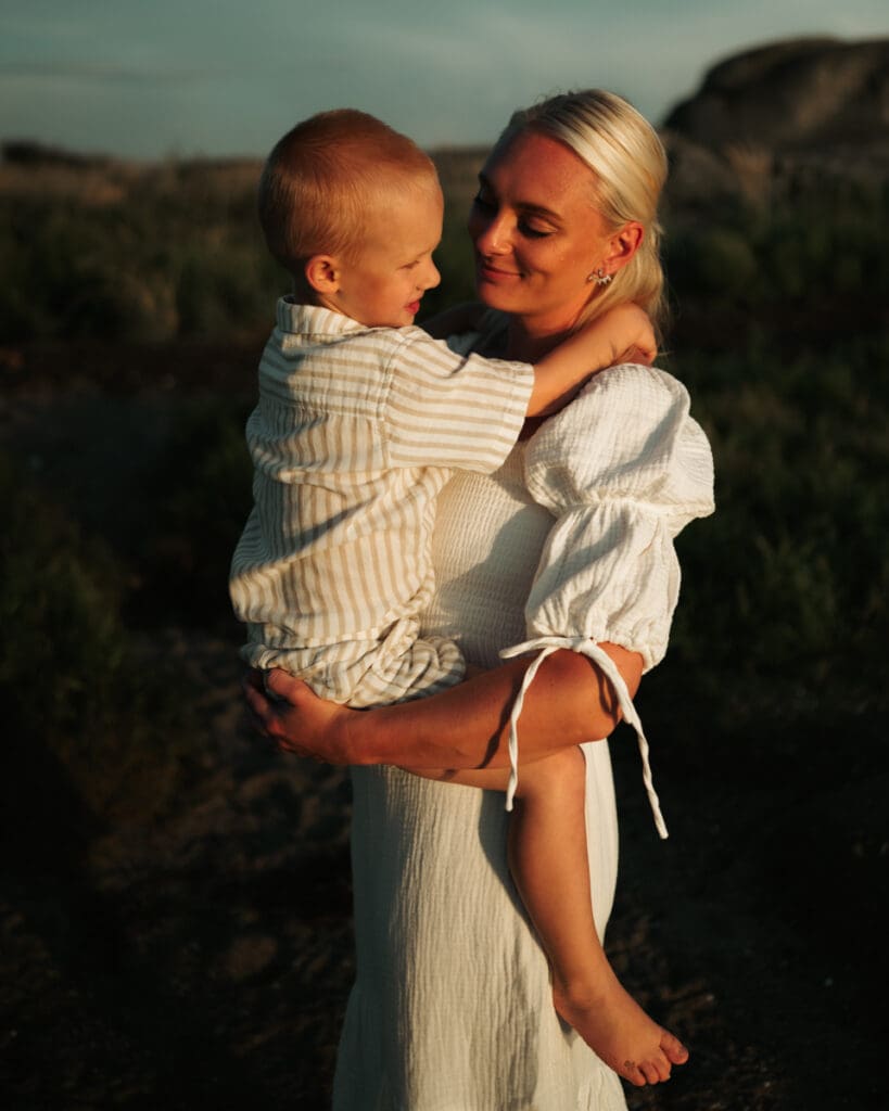 Mamma som håller sin son i famnen på Öckerö.